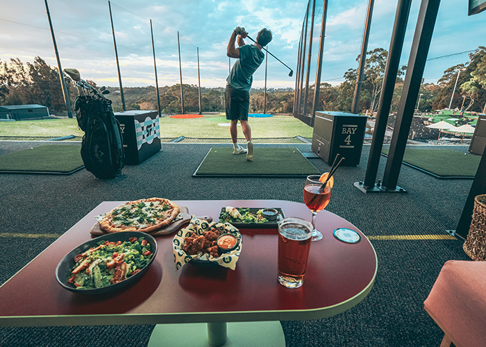 Driving Range man swinging with food and drink